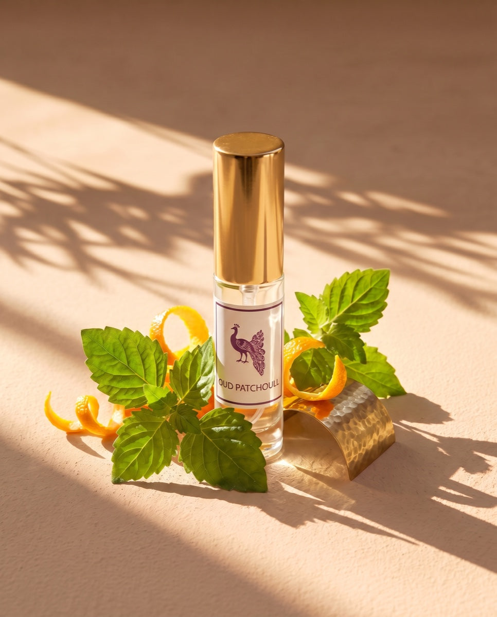 Oud Patchoull eau de parfum with patchouli leaves and mandarin in golden light